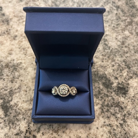 stunning Charles and Covard moissanite three stone halo engagement ring